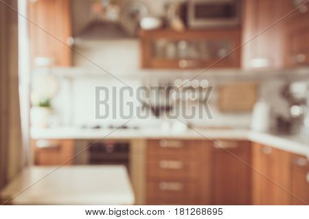 Blurred and abstract background. Empty wooden tabletop and defocused modern kitchen background for display or montage your products. Toned image.