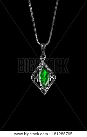 Vintage emerald pendant on a chain isolated over black