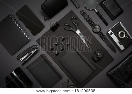 Black objects from the office on a dark gray background. Work and creativity. Social media concept hero header image. Top view. Still life. Copy space
