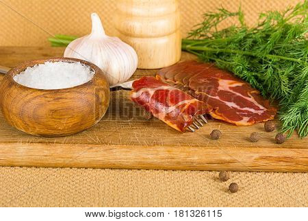 simple farm bacon stranded on a fork with pepper on wooden plate