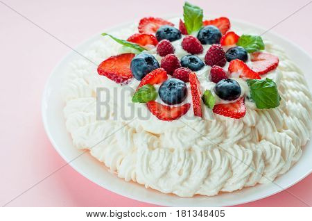 Pavlova cake with berries On a pink background