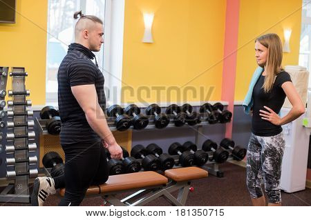 fitness, sport, exercising, technology and diet concept - smiling young woman and personal trainer with tablet pc computer in gym.