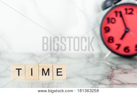 Red alarm clock on marble sureface with time text copy space