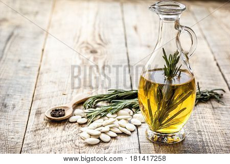 jar with natural oil with pepitas and rosemary on wooden table background mock up