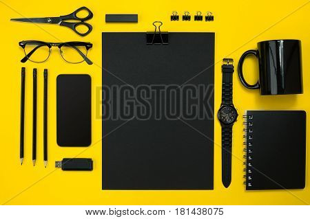 Black objects from the office on a yellow background. Work and creativity. Social media concept hero header image. Top view. Still life. Copy space