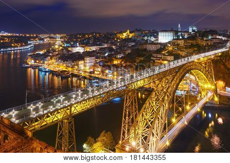 Picturesque aerial view of Old town of Porto, Ribeira and Dom Luis I or Luiz I iron bridge across Douro River at night, Portugal