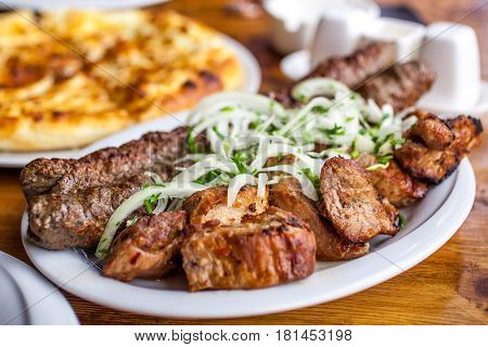 Traditional Georgian Mtsvadi Pork Barbecue And Kebab With Onion And Parsley