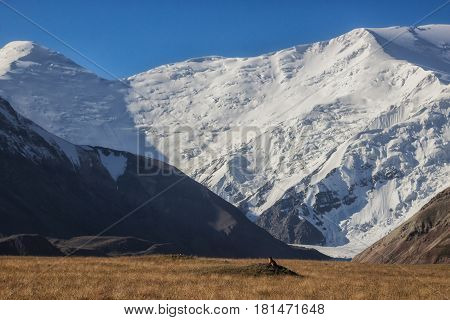 The marmot got out of the hole in the background of Lenin Peak, Pamir, Kyrgyzstan