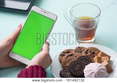 Beautiful girl holding a smartphone in the hands of a green screen green screen, hand of man holding mobile smart phone with chroma key green screen on white background, new technology concept