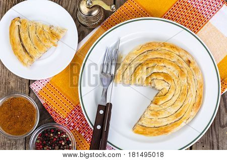 Meat burekas from puff pastry on wooden background. Studio Photo