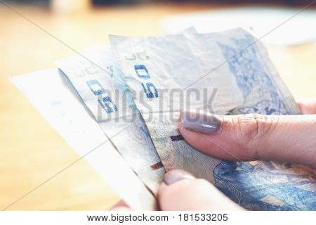 Hands holding money The cost is a fraction economy. and can be used in financial advertising.