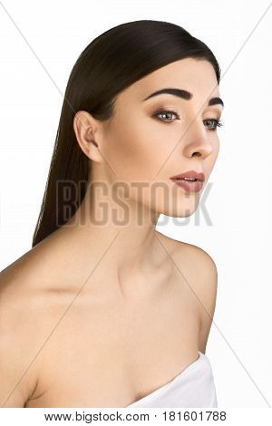Beautiful Woman Face with Clean Perfect Skin on White Background. Portrait of Beautiful Brunette with Bared Houlders. Girl Enjoying Spa. Body Care Concept.