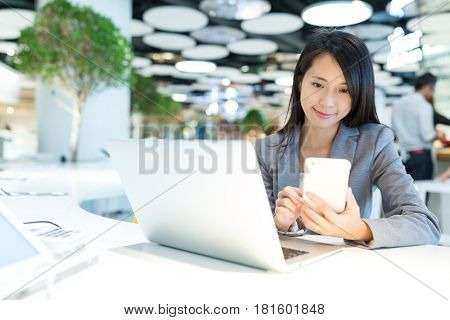 Business woman working on cellphone and laptop computer