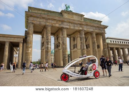 BERLIN GERMANY - MAY 23 2014: Taxi bike waiting in front of the Brandenburg Gate in Berlin Germany. A total of 5334 kilometres of roads run through the city of Berlin.
