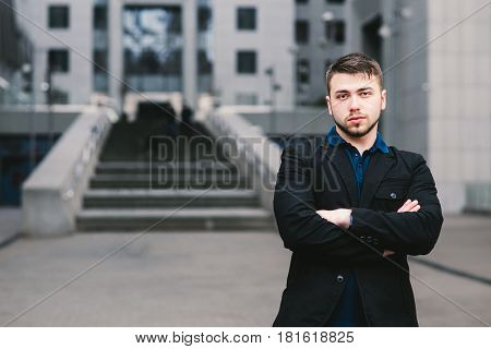 Portrait of a serious man businessman in a dark suit on a background of a modern business center.