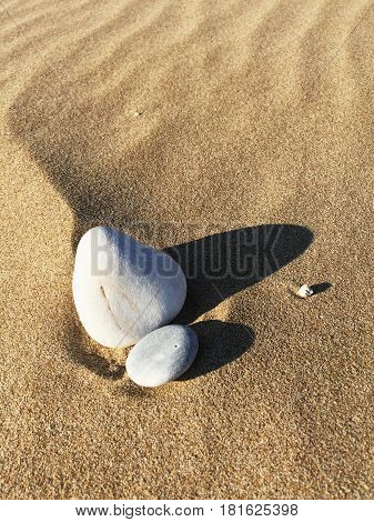 Still life stones at the sandy beach with pattern from the wind