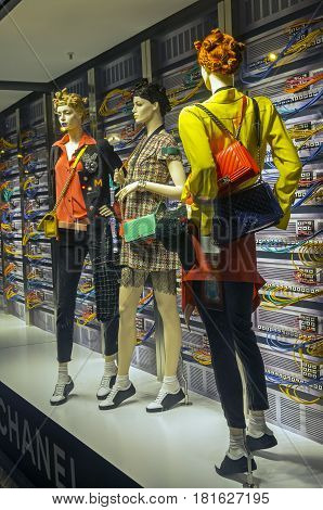 PARIS FRANCE - MARCH 27 2017: Installation in the showcase of the Printemps department store in Paris France. Fashion and high technology - elegant mannequins on the background of computer servers.