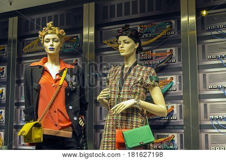PARIS FRANCE - MARCH 27 2017: Installation in the showcase of the Printemps department store in Paris France. Fashion and high technology - elegant mannequins on the background of computer servers.