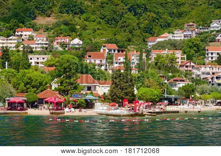 BAOSICI MONTENEGRO - SEPTEMBER 16 2015: Beautiful view from sea on coast Kotor Bay Montenegro. Unknown people are resting on beach of resort town of Baosici