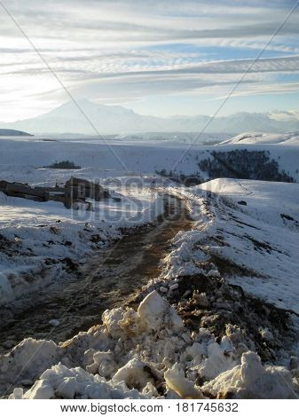 Russia Caucasia. Road and snow on mountain and blue sky background vertical view