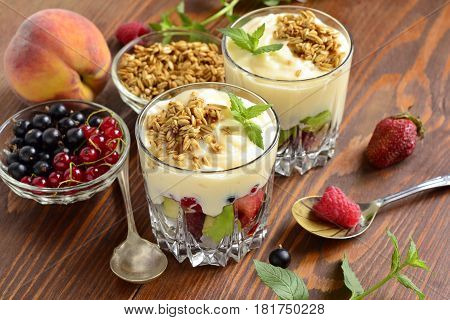 Dessert with fresh berries granola and custard in glasses