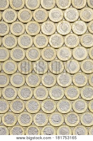 New pound coins background laid flat. Overhead point of view. The British bimetallic coin was introduced in March 2017.