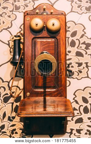 Wooden Vintage Telephone on the wall, selective focus on speaker and blurred phone