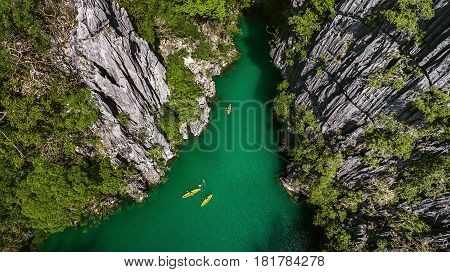 A view from above of a small lagoon in which kayaks are floating.