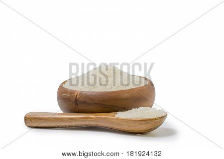white rice heap in wooden cup and spoon isolated on white background File contains a clipping path.