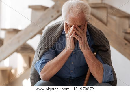 How to live. Sad crying unhappy man covering his face and crying while grieving about the person he loved