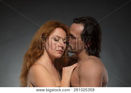 Pretty Relaxed Woman Looking Down While Tenderly Embracing Her Husband And Expressing Calmness On He
