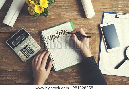 Woman Written Update Text On Notepad With Stationary On Table