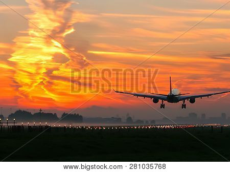 Takeoff Of A Passenger Plane On The Background Of A Sunset. Flight Of The Air Liner At Sunset.