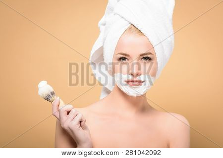Naked Woman With Towel On Head And Shaving Cream On Face Holding Shaving Brush And Looking At Camera