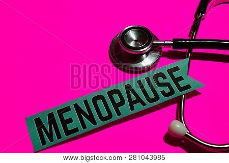 Menopause On The Paper With Healthcare Concept. With Stethoscope On Pink Bakcground