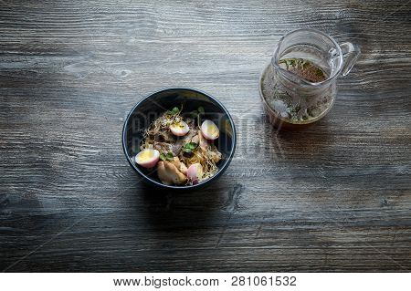 Top View Noodles Dish With Shiitake Mushrooms, Eggs, Wheat Sprouts And Pitcher With Broth