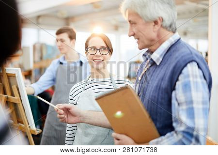 Portrait Of Smiling Young Woman Looking At Teacher During Art Class In Workshop Studio, Copy Space