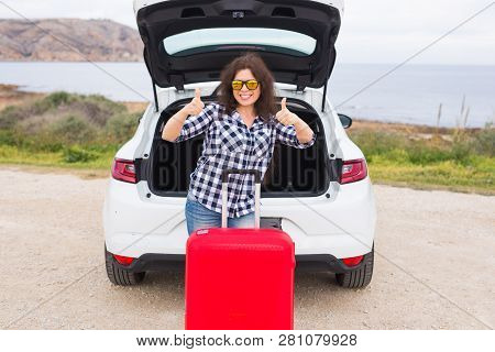 People, Vacation And Travel Concept - Young Woman With Suitcase Showing Thumbs Up Outdoors