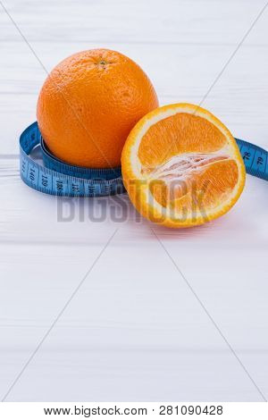 Healthy Oranges Fruits And Measuring Tape. Ripe Orange Fruits And Tape Measure On Wooden Background 
