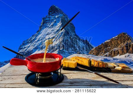 Fondue cheese, swiss winter ski holidays break for lunch, mountain view Matterhorn in Zermatt, Switzerland.