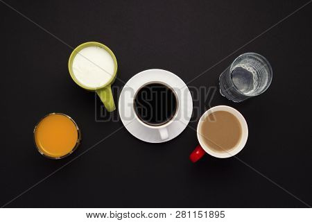 White Cup With Coffee, Just Water, Orange Juice In A Glass, Yogurt, Coffee With Milk On A Dark Backg