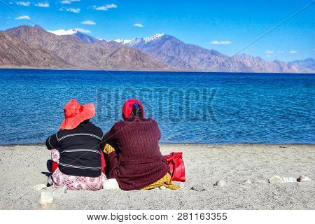 August 2018, Lake Pangong,kashmir, India. Two Tourists Sitting Beside Lake Pangong During The Day In