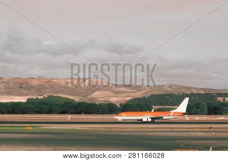 Bright Coral, Orange Color Passenger Airliner On Runway Ready To Take Off Or Landing