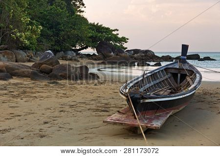 Boat on the beach at sunset in tide time. Nai Yang beach. Phuket. Thailand