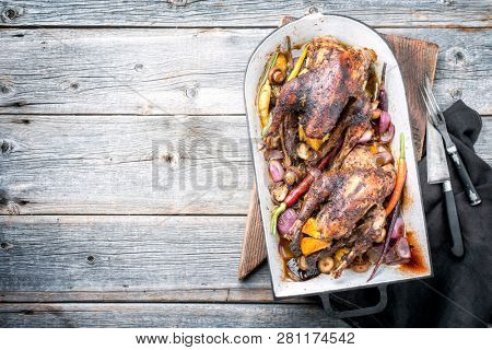 Traditional barbecue pheasant with vegetable and game sauce as top view in a stewpot with copy space left 