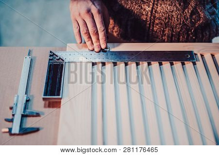 Woodwork And Furniture Making Concept. A Carpenter In The Workshop Marks Out And Installs The Furnit