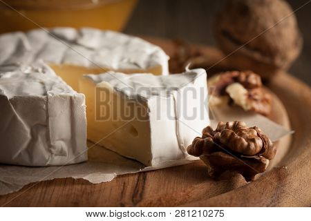 Camembert And Brie Cheese On Wooden Background With Tomatoes, Letuce And Garlic. Italian Food. Dairy