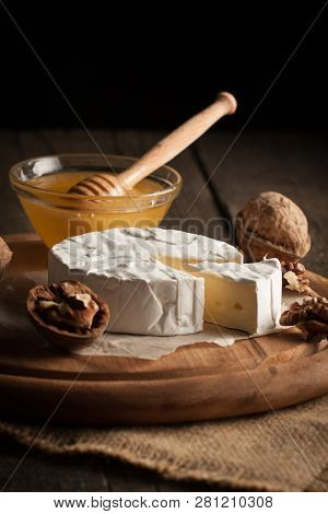 Camembert And Brie Cheese On Wooden Background With Tomatoes, Letuce And Garlic. Italian Food. Dairy