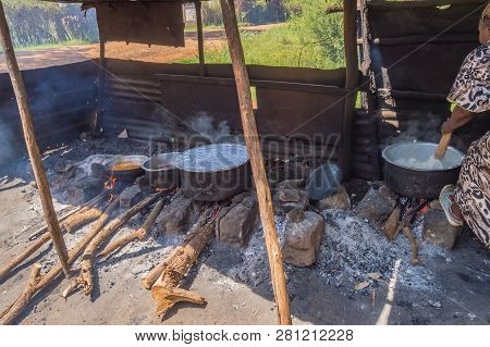 Four Large Saucepans Resting On Log Fires In A Small Stall Of A Restaurant Near The City Of Thika In