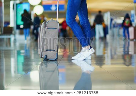 Closeup Of Woman Legs With Luggage In International Airport. Tourism And Travel Concept